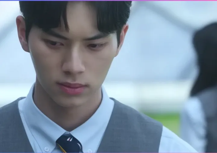 Близък план на момче със синя вратовръзка, в гръб е с момиче. 