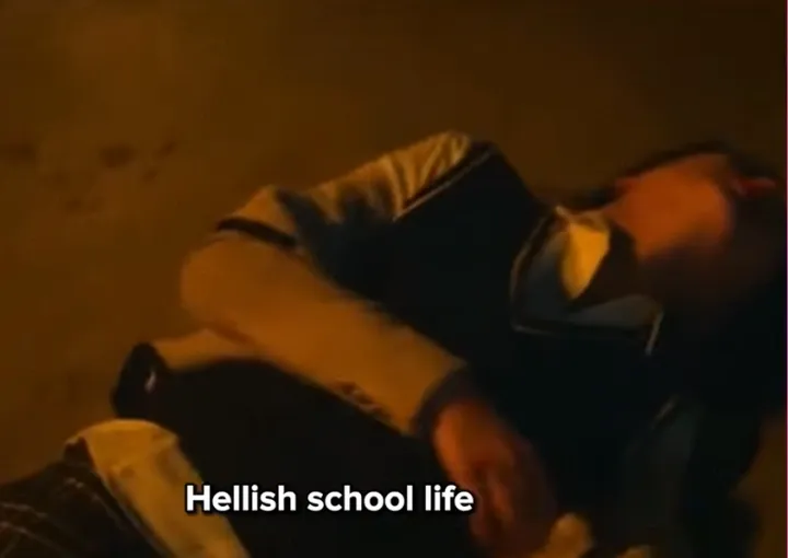 Момиче в училищна униформа се свива от болка, вероятно е бито. 